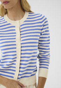 Lightweight cotton cardigan with cream and blue horizontal stripes, button closure, ribbed neckline and cuffs, form-fitting design.