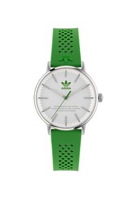 Zaļš silikona siksniņas pulkstenis ar sudraba nerūsējošā tērauda korpusu, balto ciparnīcu un zaļu logotipu. Iezīmē vienkāršas stundu marķierus un perforētu siksniņas dizainu.