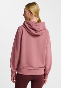 Rosa Kapuzenpullover mit entspannter Passform, gerippten Bündchen und Saum. Glatte Textur, große Kapuze und sichtbare Rückennähte.