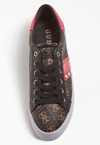 Baskets noires et brunes à motifs avec une touche de rouge, œillets en or et clous décoratifs. Présentent une surface texturée et une semelle blanche.