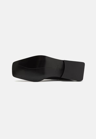 Semelle de chaussure en cuir noir avec un design lisse et plat, présentant une légère courbe et une forme de orteil rectangulaire. Comprend un détail de marque minimal.