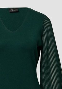 Dunkelgrüner Strickpullover mit V-Ausschnitt und geripptem Muster am Körper, ausgestattet mit plissierten, durchsichtigen langen Ärmeln.
