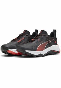 Scarpe sportive nere e grigie con dettagli rossi, tomaia in rete, colletto imbottito e suola testurizzata per aderenza. Lacci e marchio visibili.