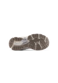 Semelle de chaussure de sport grise et beige dotée d'un motif de caoutchouc avec des textures et des motifs variés, une section centrale lisse, et le logo New Balance.