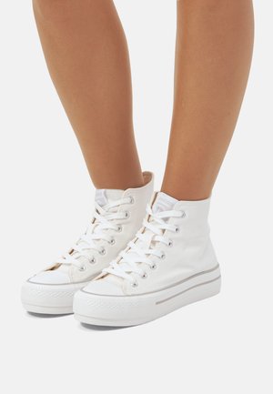 Sneakers bianchi in tela alta con punta rotonda, chiusura con lacci e suola in gomma. Presentano occhielli metallici e una sottile striscia grigia sulla suola.