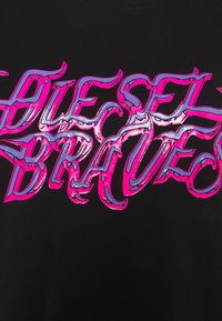 Stylizovaný text "DIESEL BRAVES" v růžové a fialové barvě s jagged, plamennými okraji na černém pozadí.