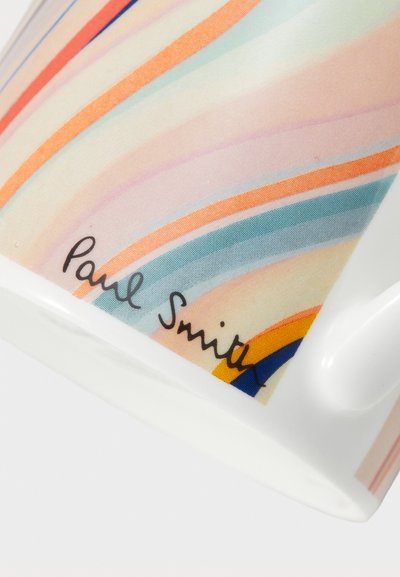 Caneca de cerâmica com um design listrado em cores pastéis, apresentando finas linhas laranja, azul e rosa. Assinada "Paul Smith" em cursivo preto.