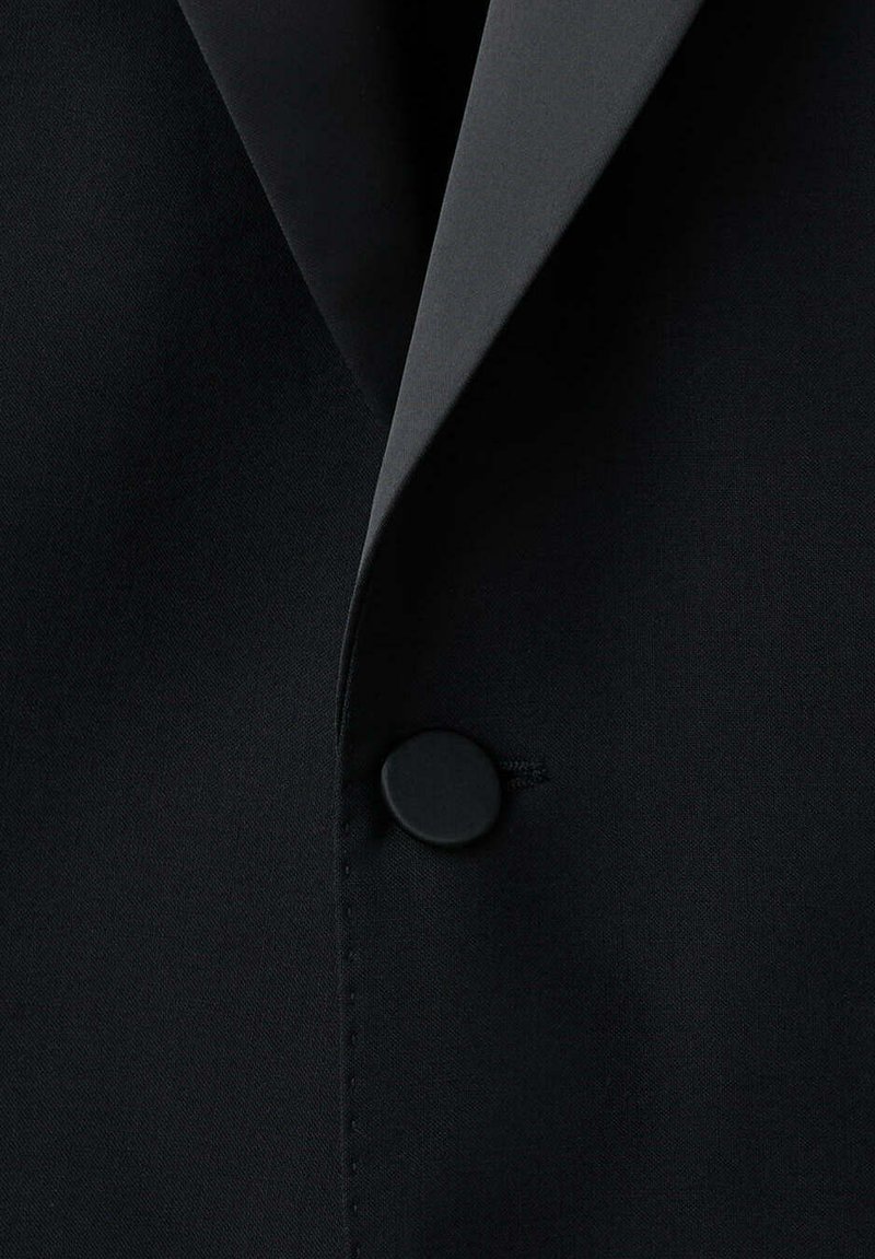 Blazer negro entallado con un único botón cubierto y un cuello de solapa con muesca afilada.