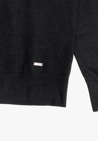 Zwarte gebreide trui met een geribde onderkant en manchetten, voorzien van een klein wit merkteken met een accentueerdetail in rode steek.