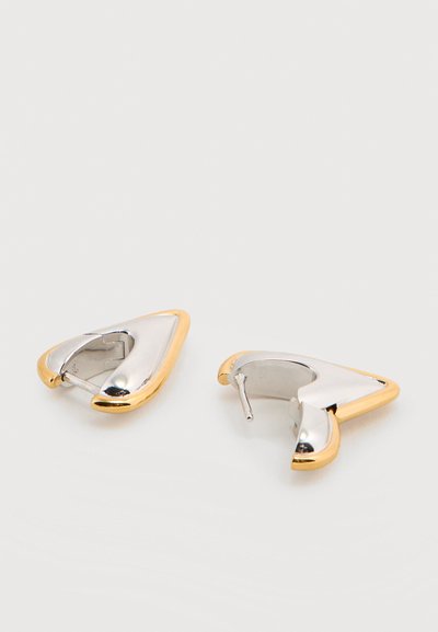 Τρίγωνα σκουλαρίκια κρίκοι σε ασημί και χρυσό τόνο με γυαλιστερό φινίρισμα, το ένα δείχνει το μπροστινό μέρος και το άλλο την πίσω πλευρά με το κούμπωμα.