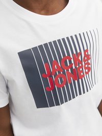 Camiseta de algodón blanca con un diseño gráfico que presenta "JACK & JONES" en letras rojas en negrita sobre rayas grises verticales. Cuello redondo.