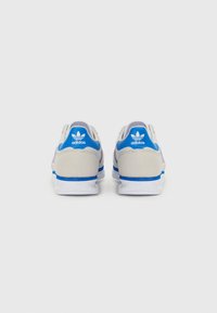 Ténis Adidas com uma combinação de cores cinza e azul, textura suave, colarinho acolchoado e sola branca de borracha com acentos do logótipo.