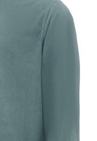 Fleece top i dæmpet teal, med en blød, tekstureret overflade og sømløse manchetter, der fremhæver et afslappet og komfortabelt design.