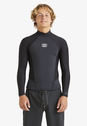 Black long-sleeve rash guard made of stretchy material; features a high neckline and logo on the chest; paired with dark swim shorts.