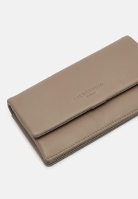 Beżowy skórzany portfel o gładkiej fakturze, składanym kształcie, wytłoczonym logo i starannym przeszyciu wzdłuż krawędzi. Kompaktowy i prostokątny kształt.