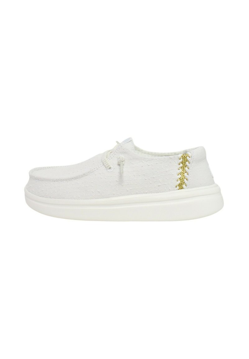 Zapatilla de lona blanca con parte superior texturizada, puntera redondeada y un detalle de costura dorada en el talón. Suela de goma blanca.