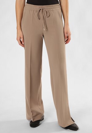 Light brown, wide-leg trousers with an elastic waistband and drawstring. Smooth fabric, features small side slits at the hem.
