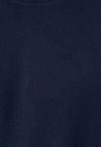 Mörkblått tyg med en slät yta, med jämna sömmar och en klassisk rundhalsdesig. Idealisk för avslappnad användning.