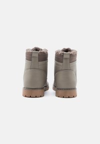 Sturdy gray ankle boots with a soft brown fur lining, rubber soles, and smooth leather exterior, featuring stitched accents on the sides.