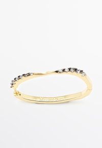 Bracelet en or avec un design ondulé orné de petites pierres précieuses claires sur le dessus. Gravé du nom de la marque "Massimo Dutti" à l'intérieur.