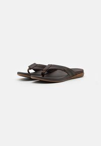 Bruine flip-flops met rubberen zolen, gestructureerde banden en een teenpostontwerp. Bevat geperforeerde details en een glad voetbed.