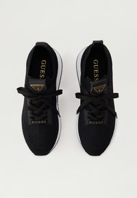 Schwarze gestrickte Sportschuhe mit strukturiertem Obermaterial, runder Zehenpartie und kontrastierender weißer Gummisohle. Verfügt über doppelte "GUESS"-Logoakzente und schwarze Schnürsenkel.