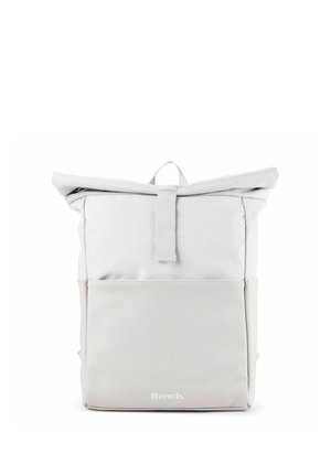 Sac à dos roll-top gris clair minimaliste avec poche avant et logo "Bench." centré en bas devant.