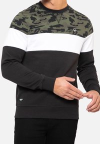 Heren sweatshirt met een camoufleringspatroon op de schouders, witte en zwarte horizontale strepen, geribbelde manchetten en een klein logo op de borst.