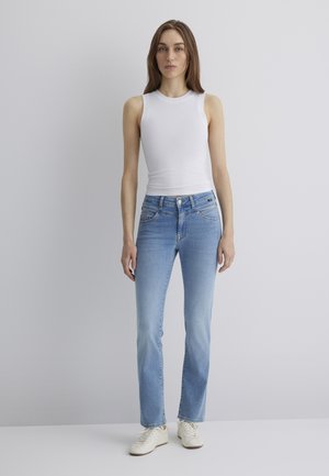 Light blue straight-leg jeans made of denim, featuring five pockets, subtle whiskering, and a mid-rise waist. Paired with a white tank top.