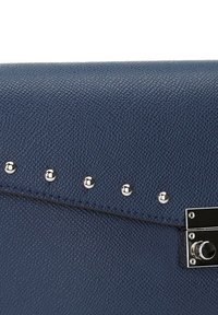 Mörkblå strukturerad läderhandväska med silvernitar längst upp och en metallisk knäppning på sidan.