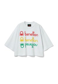 Bílé oversized tričko s barevným potiskem v červené, žluté a zelené barvě. Jemný bavlněný materiál s kulatým výstřihem a širokými rukávy.