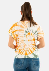 T-shirt à manches courtes en tie-dye présentant des motifs en spirale orange, vert et blanc ; tissu doux avec une coupe décontractée ; encolure ronde, design court.