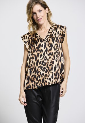 Bluse mit Leopardenmuster aus leichtem Stoff, mit einem V-Ausschnitt und kurzen Ärmeln, kombiniert mit schwarzen, locker sitzenden Hosen.