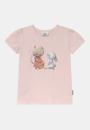 T-shirt rose clair pour tout-petit avec une impression représentant un chat tenant un panier et un lapin assis à côté, tous deux dans des couleurs pastel douces.