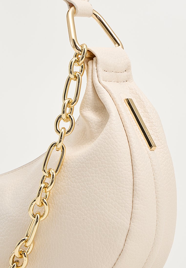 Borsa a spalla in pelle beige con una superficie texturizzata, dotata di una tracolla in catena dorata e un accento rettangolare. Forma curva con cuciture dettagliate.