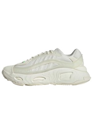 Baskets de sport blanches avec semelle épaisse et texturée, détails subtils de rayures sur le côté, vues de la gauche sur fond blanc uni.