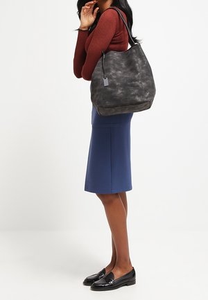 Musta nahkainen hobo-laukku, jossa on pehmeä, teksturoitu pinta. Laukussa on yksi olkahihna ja siinä on huomaamaton bränditagi kiinnitettynä.