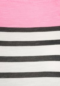 Lightweight cotton top with pink neckline, featuring horizontal black and white stripes. Soft texture with a relaxed fit.
