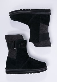 Schwarze Wildlederstiefel mit einer gesteppten grauen Seite, ausgestattet mit einem verstellbaren Riemen, einer runden Zehenpartie und einer strukturierten Gummisohle für Grip.