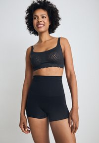 Svart blondebralette med scallopkant og brede stropper, kombinert med høy midje svarte shorts, mykt stoff med en glatt tekstur.