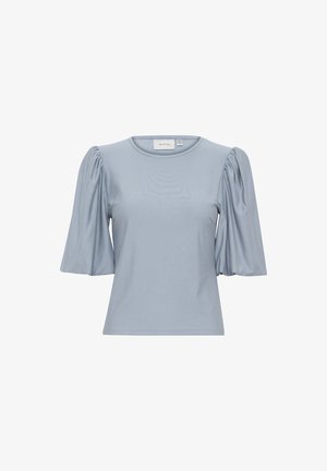 Svijetloplava majica kratkih rukava od glatke tkanine; ima okrugli izrez i napuhane rukave za dodatni volumen i teksturu.