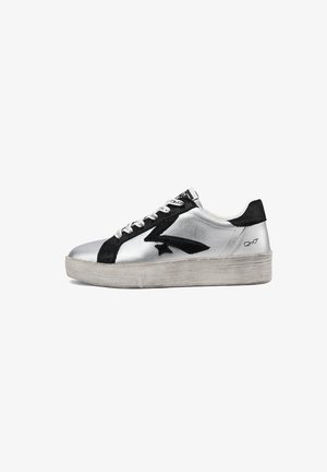 Sneaker argento basso con design a stella nera e fulmine, lacci bianchi, linguetta posteriore nera e suola spessa in gomma usurata.