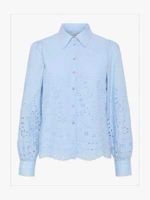Világoskék blúz gombos elülső részel, hegyes gallérral, hosszú puffos ujjakkal és hímes lyukasztott mintával. Hullámos szegélydíszítés.