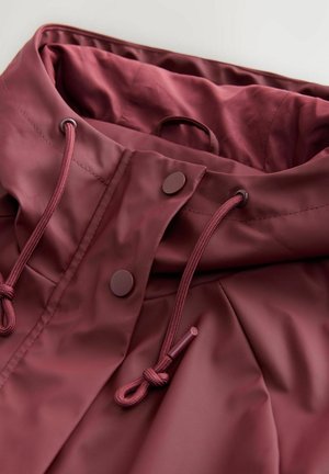 Maroon rain jacket collar close-up features a smooth, glossy finish, drawstring, and snap buttons for secure closure.