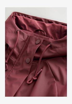 Maroon rain jacket collar close-up features a smooth, glossy finish, drawstring, and snap buttons for secure closure.