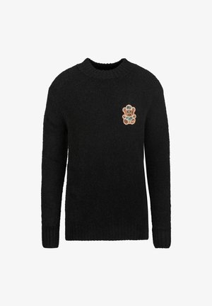 Schwarzer gestrickter Pullover mit langen Ärmeln und rundem Ausschnitt; verfügt über einen bunten Teddybären-Patch auf der linken Brust.