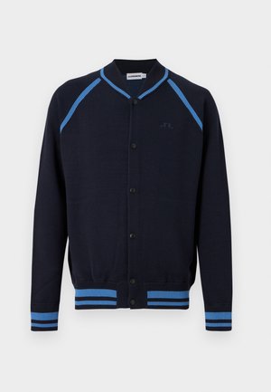 Marineblauwe cardigan met knopen, lichtblauwe strepen op schouders, manchetten en zoom, voorzien van een geribde kraag en een subtiel logo op de borst.