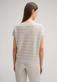 Lichtgrijze sweater met korte mouwen en textuur horizontale strepen in een lichtere tint. Ribbelnek en -zoom, met een klein logo op de achterkant.
