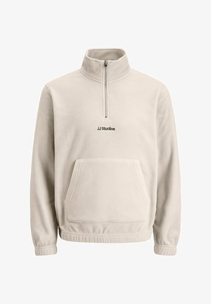 Smėlio spalvos fliso megztinis su pusiau užtrauktuku, kengūros kišene, elastingomis rankovėmis ir išsiuvinėtu "JJ Studios" logotipu ant krūtinės.