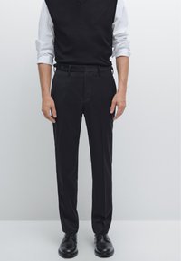 Black trousers with a tailored fit, featuring belt loops and front pockets. Made from smooth fabric with a flat front design.